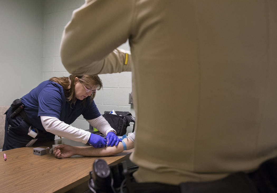 EMT Katharine York, left, draws blood from a suspected impaired driver at the Metro Traffic Bureau as part of a "DUI blitz" on Thursday, March 14, 2019, in Las Vegas. (Benjamin Hager Rev ...