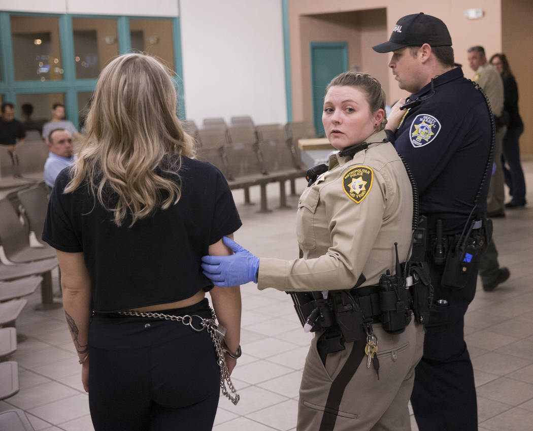 Metro Officer B. Muenzenmeyer, middle, processes a suspected impaired driver at the Metro Traffic Bureau as part of a "DUI blitz" on Thursday, March 14, 2019, in Las Vegas. (Benjamin Hag ...