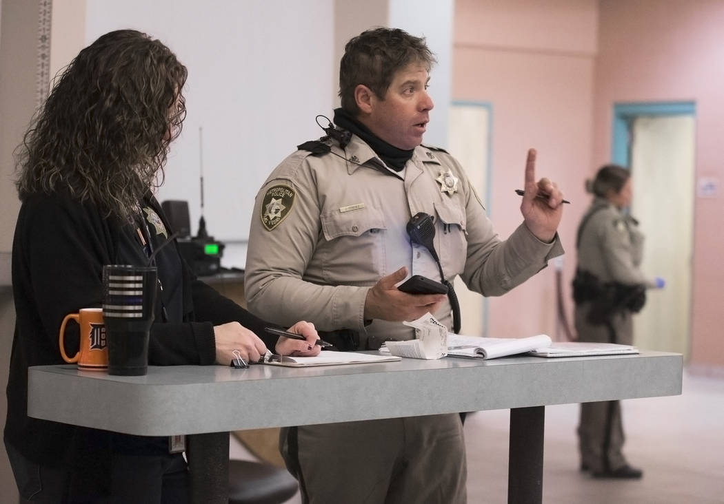 Metro Traffic Officer Jason Strehle, middle, questions a suspected impaired driver (out of frame) at the Metro Traffic Bureau as part of a "DUI blitz" on Thursday, March 14, 2019, in Las ...