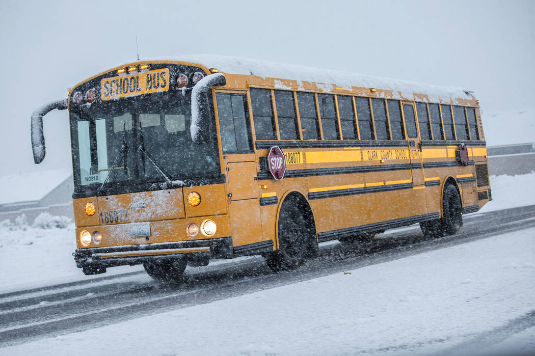 School buses make their way through heavy snow to Centennial High School on Thursday, Feb. 21, 2019, in Las Vegas. (Benjamin Hager Review-Journal) @BenjaminHphoto