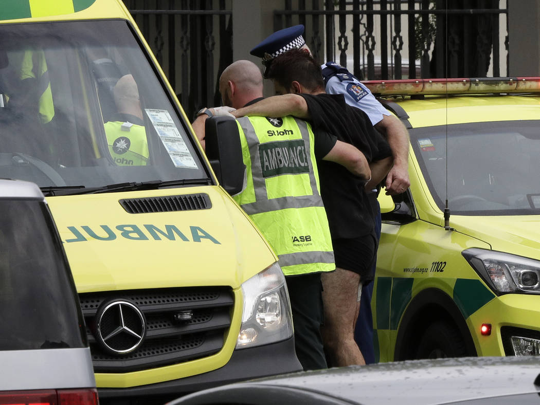Police and ambulance staff help a wounded man from outside a mosque in central Christchurch, New Zealand, Friday, March 15, 2019. (AP Photo/Mark Baker)