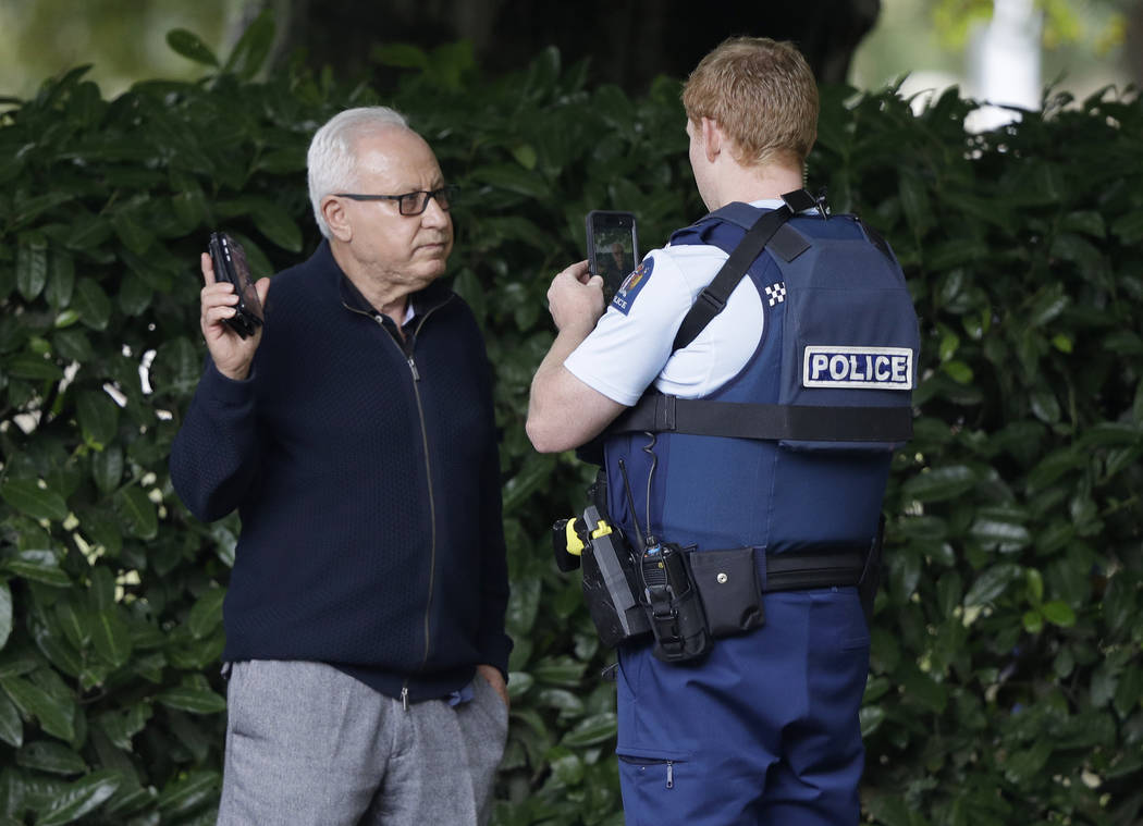 A police officer photographs a witness near a mosque in central Christchurch, New Zealand, Friday, March 15, 2019. Multiple people were killed in mass shootings at two mosques full of people atte ...