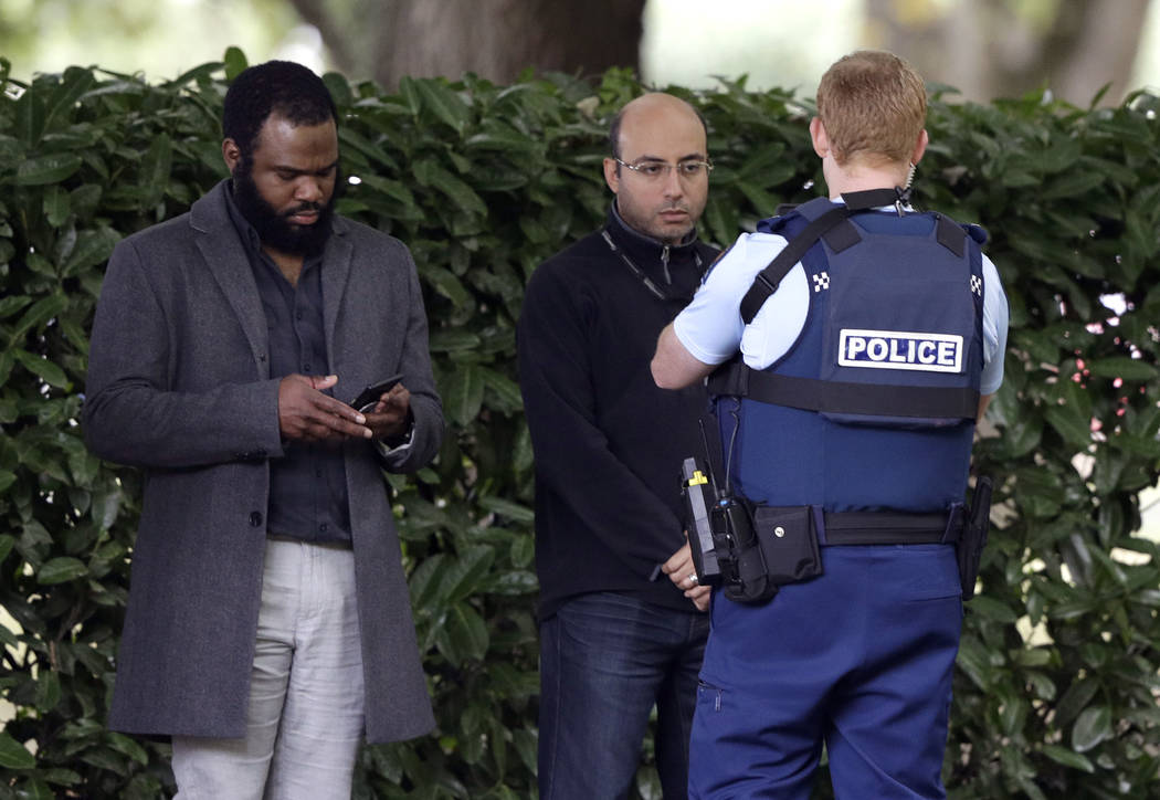 A police officer photographs witnesses near a mosque in central Christchurch, New Zealand, Friday, March 15, 2019. Multiple people were killed in mass shootings at two mosques full of people atten ...