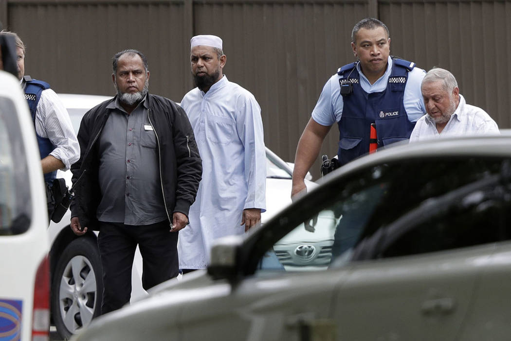 Police escort men from a mosque in central Christchurch, New Zealand, Friday, March 15, 2019. (AP Photo/Mark Baker)
