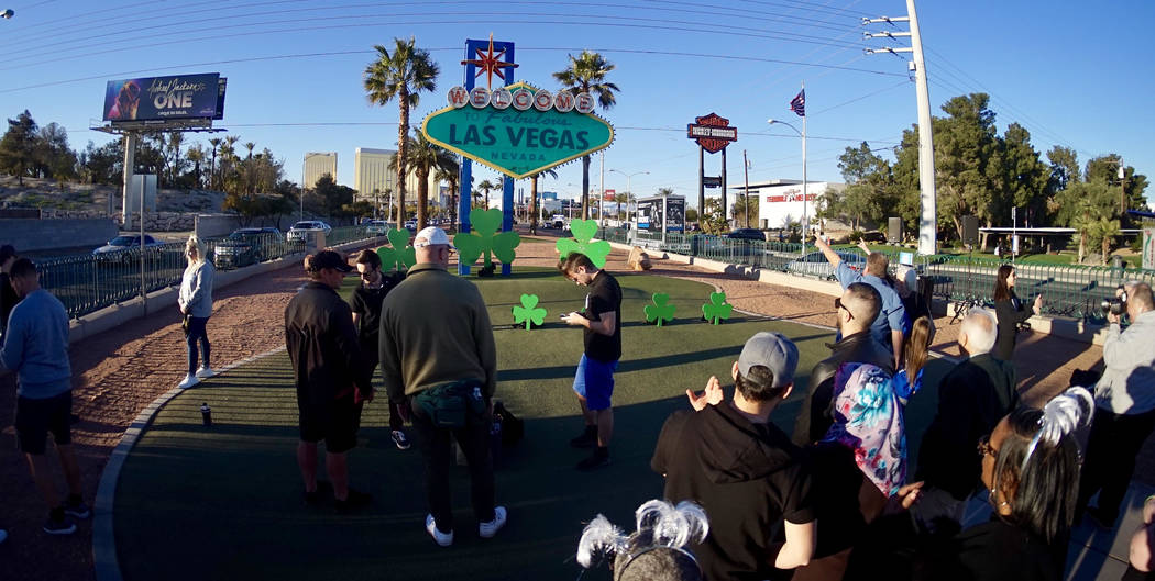 A crowd gathers at the "Welcome to Fabulous Las Vegas" sign on Thursday, March 14, 2019. The sign was lit green in celebration of St. Patrick's Day. (Mat Luschek/Las Vegas Review-Journal)