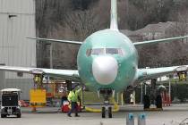 In this March 11, 2019, file photo a worker stands near a Boeing 737 MAX 8 airplane parked at Boeing Co.'s Renton Assembly Plant in Renton, Wash. Boeing soared early in 2019 and lifted the Dow Jon ...