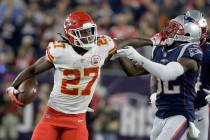 Kansas City Chiefs running back Kareem Hunt (27) gives a stiff arm to New England Patriots defensive back Devin McCourty (32) as he runs for yardage during the first half of an NFL football game, ...