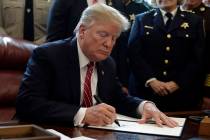 President Donald Trump signs the first veto of his presidency in the Oval Office of the White House, Friday, March 15, 2019, in Washington. Trump issued the first veto, overruling Congress to prot ...