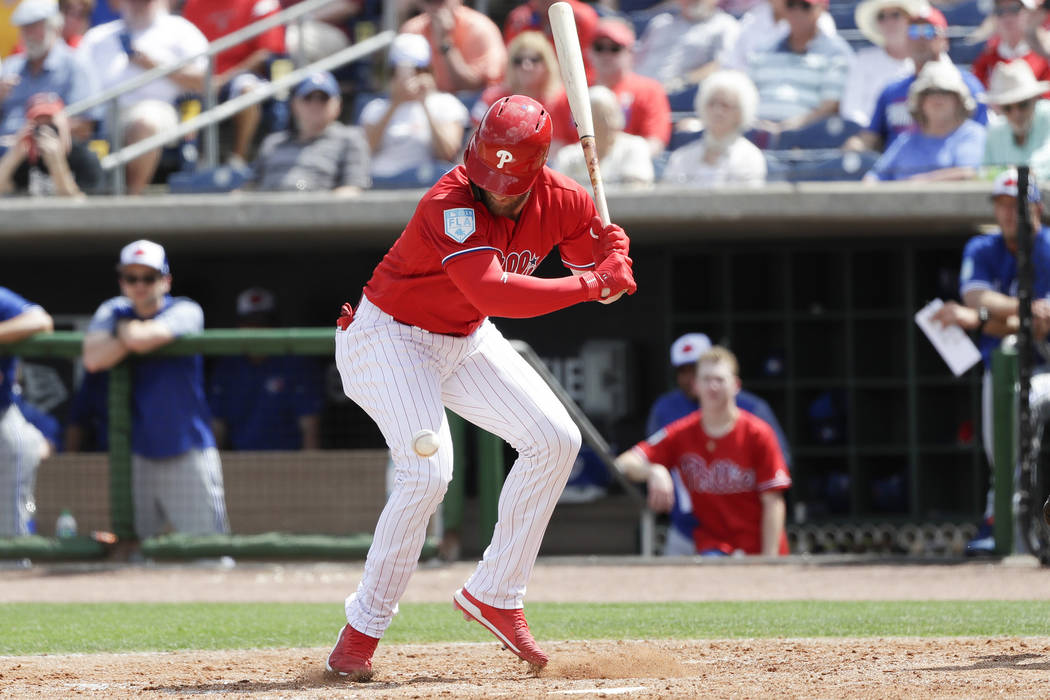 Philadelphia Phillies' Bryce Harper looks down at the baseball after getting hit by a pitch during the sixth inning in a spring training baseball game against the Toronto Blue Jays, Friday, March ...