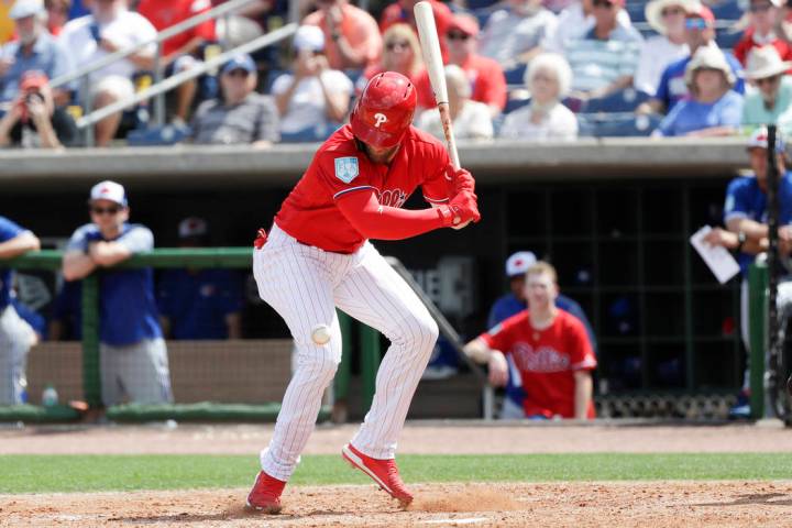 Philadelphia Phillies' Bryce Harper looks down at the baseball after getting hit by a pitch during the sixth inning in a spring training baseball game against the Toronto Blue Jays, Friday, March ...