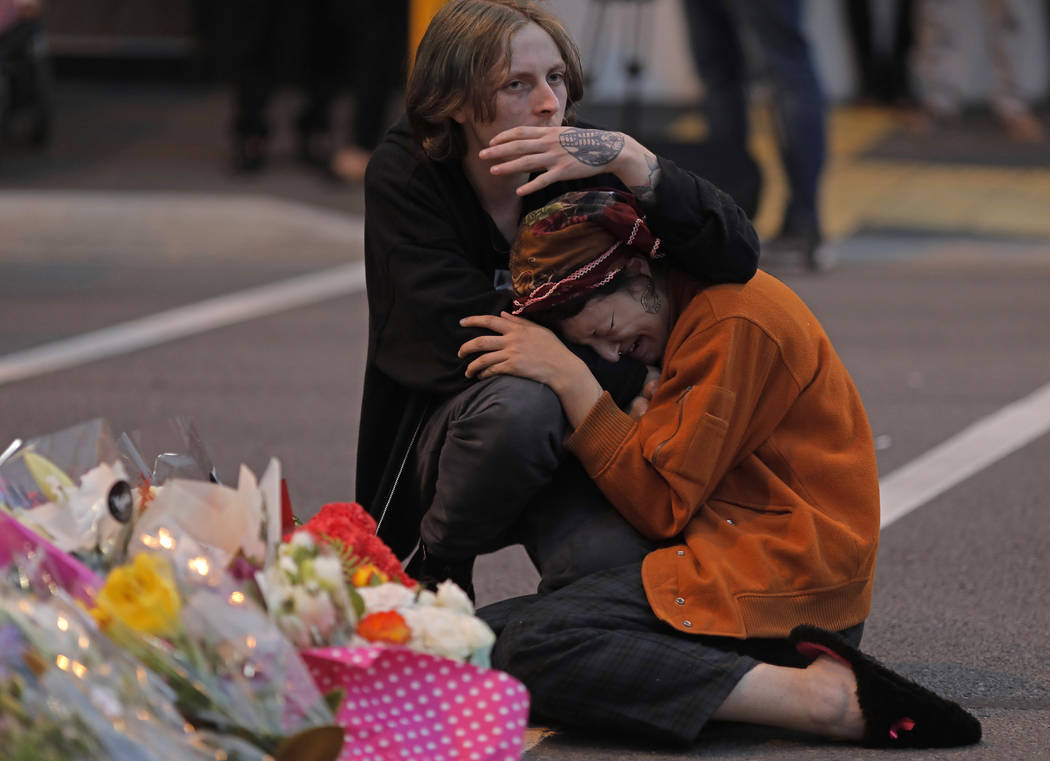 Mourners pay their respects at a makeshift memorial near the Masjid Al Noor mosque in Christchurch, New Zealand, Saturday, March 16, 2019. New Zealand's stricken residents reached out to Muslims i ...