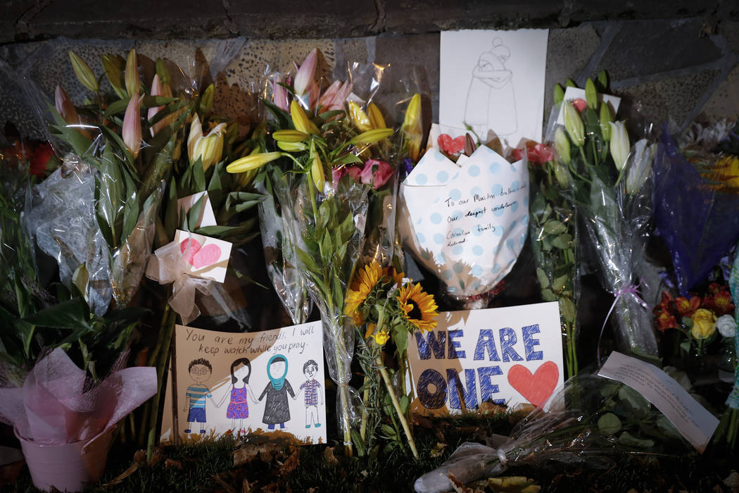Mourners place flowers as they pay their respects at a makeshift memorial near the Masjid Al Noor mosque in Christchurch, New Zealand,, Saturday, March 16, 2019. New Zealand's stricken residents r ...