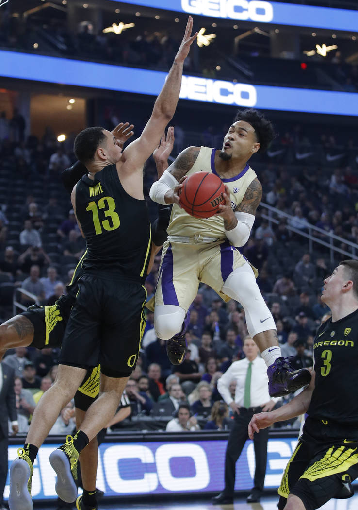 Washington's David Crisp shoots around Oregon's Paul White during the first half of an NCAA college basketball game in the final of the Pac-12 men's tournament Saturday, March 16, 2019, in Las Veg ...