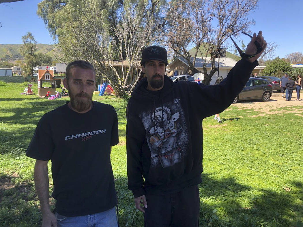Neighbors, Josh Nunnally, left, and Albert Ortega explain that they thought the pilot was fighting the wind before crashing in Riverside, Calif., Saturday, March 16, 2019. (Brian Rokos/The Orange ...