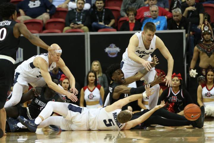 Utah State Aggies and San Diego State Aztecs fight for a loss ball in the second half of the Mountain West tournament men's basketball championship game at the Thomas & Mack Center in Las Vega ...