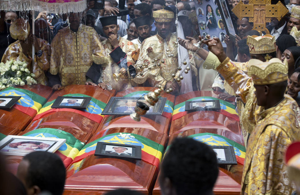 Priests swing incense over empty caskets draped with the national flag at a mass funeral at the Holy Trinity Cathedral in Addis Ababa, Ethiopia Sunday, March 17, 2019. Thousands of Ethiopians have ...