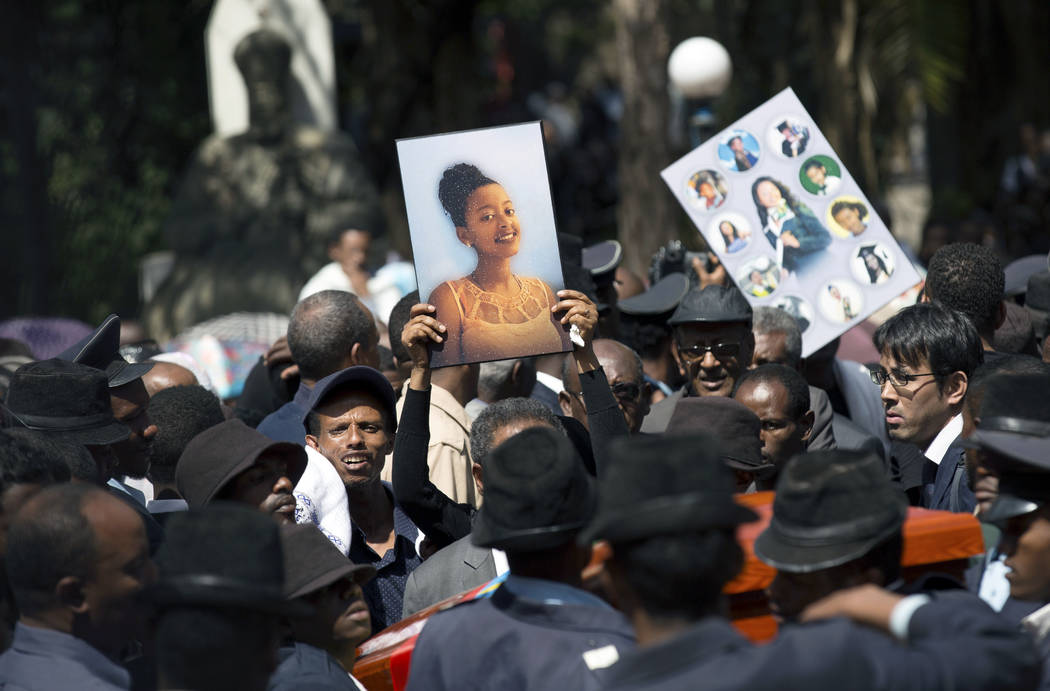 Relatives hold photographs of the victims at a mass funeral at the Holy Trinity Cathedral in Addis Ababa, Ethiopia Sunday, March 17, 2019. Thousands of Ethiopians have turned out to a mass funeral ...