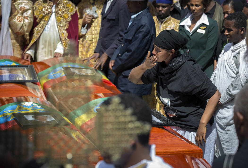 A relative blows a kiss towards empty caskets draped with the national flag at a mass funeral at the Holy Trinity Cathedral in Addis Ababa, Ethiopia Sunday, March 17, 2019. Thousands of Ethiopians ...