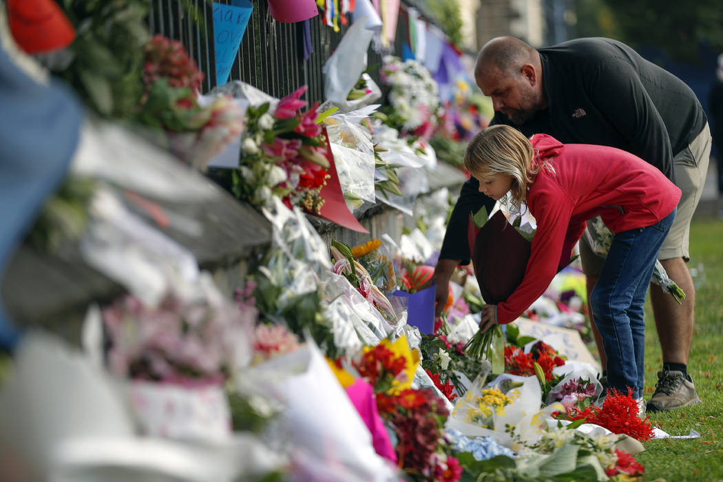 Mourners lay flowers on a wall at the Botanical Gardens in Christchurch, New Zealand, Saturday, March 16, 2019. New Zealand's stricken residents reached out to Muslims in their neighborhoods and a ...