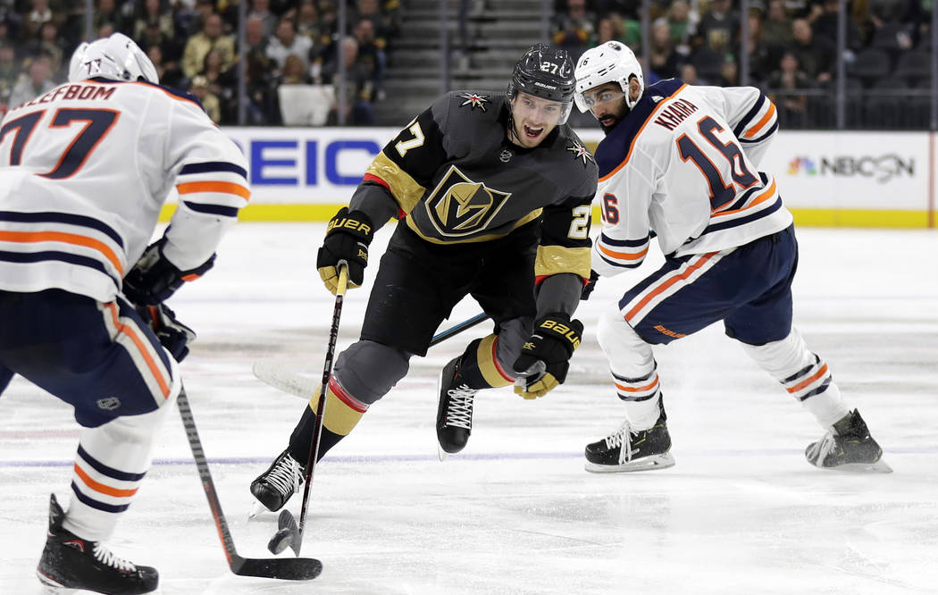 Vegas Golden Knights defenseman Shea Theodore (27) skates with the puck through Edmonton Oilers defenders during the second period of an NHL hockey game Sunday, March 17, 2019, in Las Vegas. (AP P ...