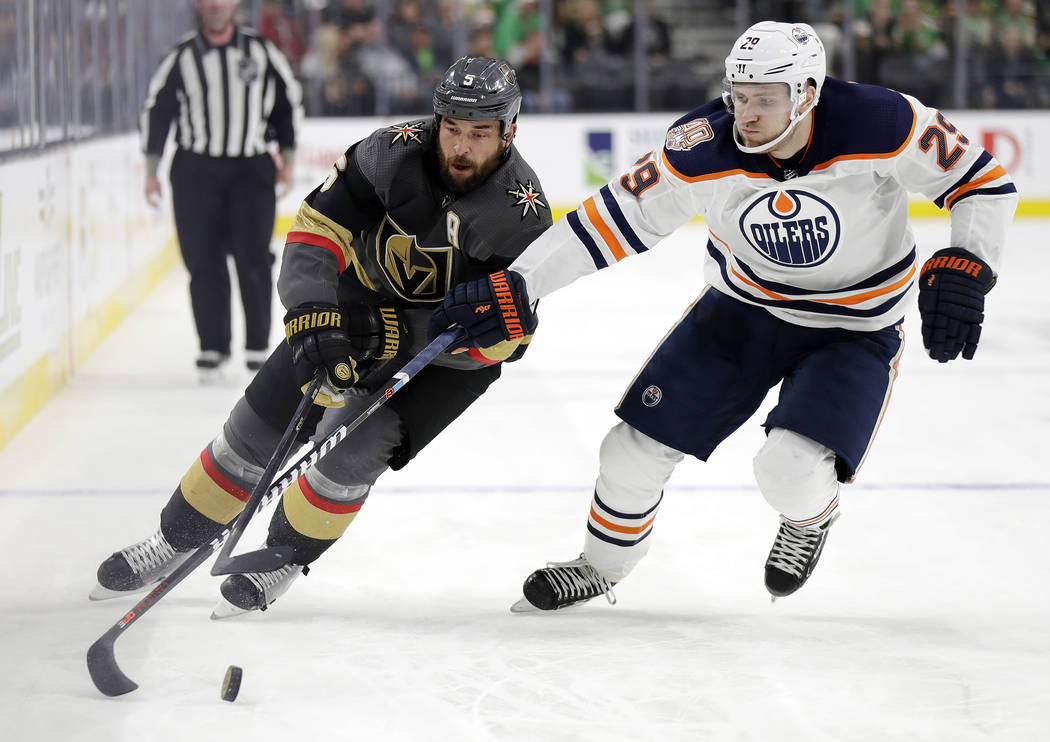 Vegas Golden Knights defenseman Deryk Engelland (5) skates with the puck as Edmonton Oilers left wing Leon Draisaitl defends during the second period of an NHL hockey game Sunday, March 17, 2019, ...