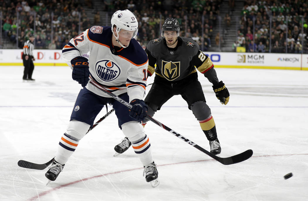 Edmonton Oilers center Colby Cave (12) takes a shot as Vegas Golden Knights defenseman Shea Theodore defends during the third period of an NHL hockey game Sunday, March 17, 2019, in Las Vegas. The ...