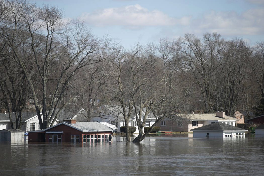The Rock River crested its banks and floods Shore Drive, seen here on Saturday, March 16, 2019, from the Bauer Parkway bridge in Machesney Park, Ill. Many rivers and creeks in the Midwest are at r ...