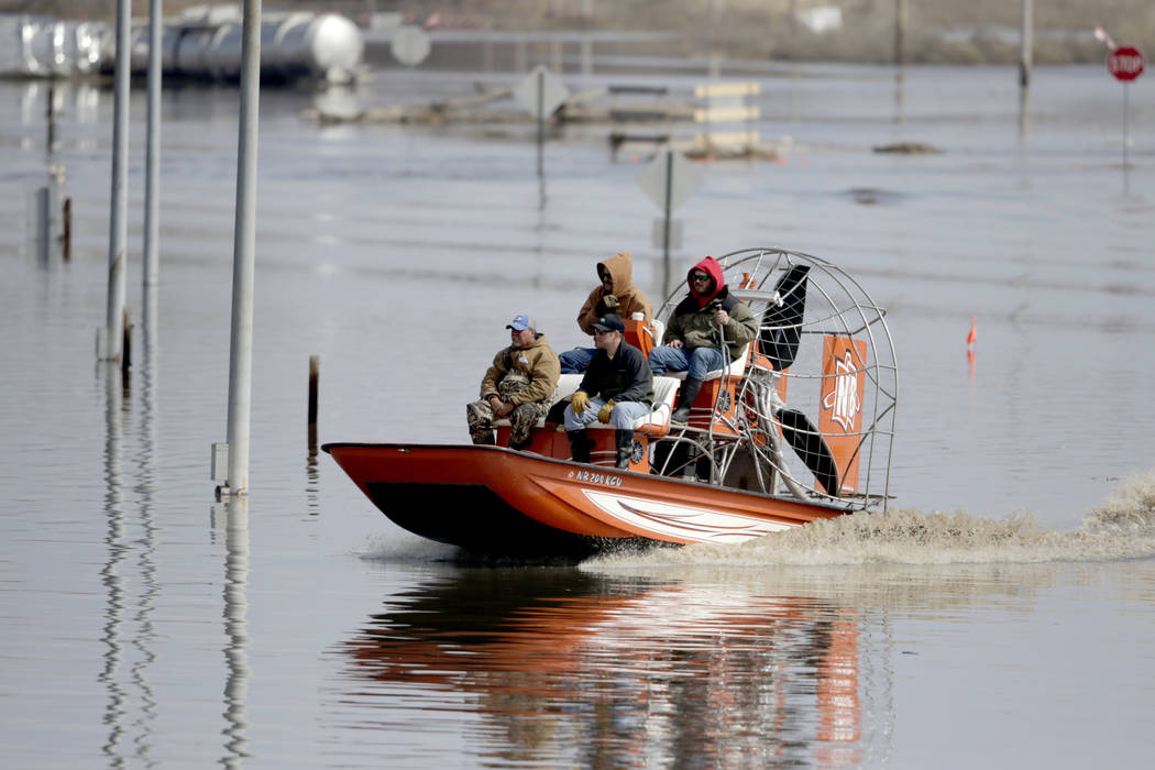 Gabe Schmidt, owner of Liquid Trucking, back right, travels by air boat with Glenn Wyles, top left, Mitch Snyder, bottom right, and Juan Jacobo, bottom left, as they survey damage from the flood w ...