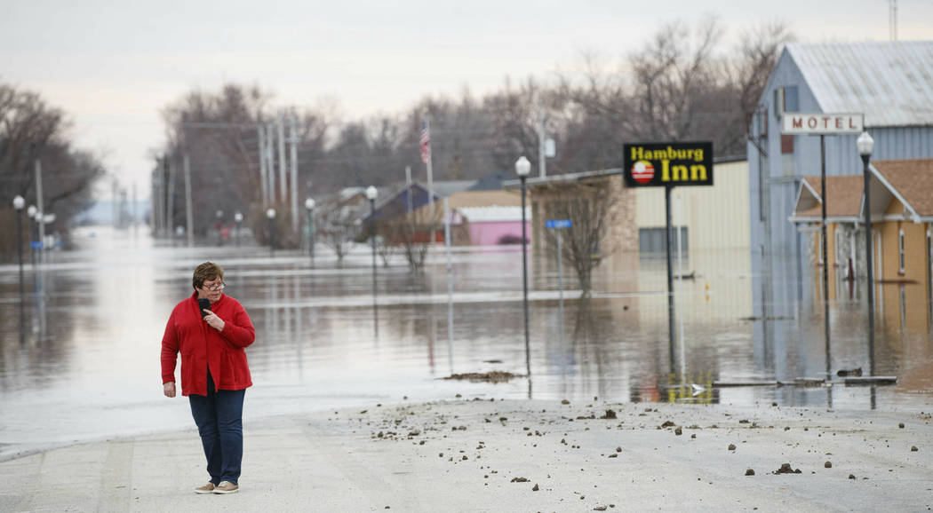 Lana Brandt checks out the rising water on the south side of the Hamburg, Iowa, Sunday, May 17, 2019, Residents in parts of southwestern Iowa were forced out of their homes Sunday as a torrent of ...