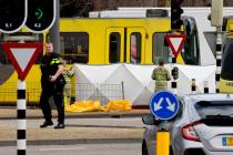 Rescue workers install a screen on the spot where a body was covered with a white blanket following a shooting in Utrecht, Netherlands, Monday, March 18, 2019. Police in the central Dutch city of ...