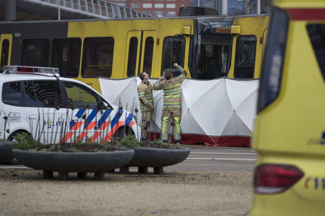 Rescue workers install a screen on the spot where a human shape was seen under a white blanket following a shooting in Utrecht, Netherlands, Monday, March 18, 2019. Police in the central Dutch cit ...