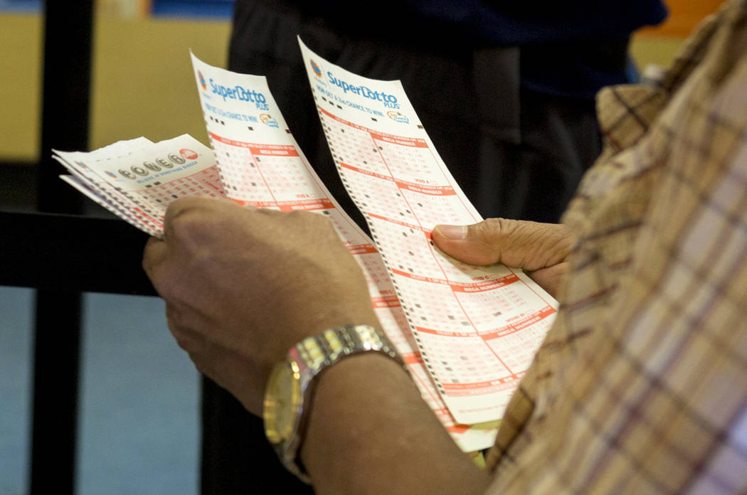 A man looks over his numbers on his Powerball tickets at the Primm Valley Lotto Store, Wednesday, Aug. 16, 2017. Elizabeth Brumley Las Vegas Review-Journal