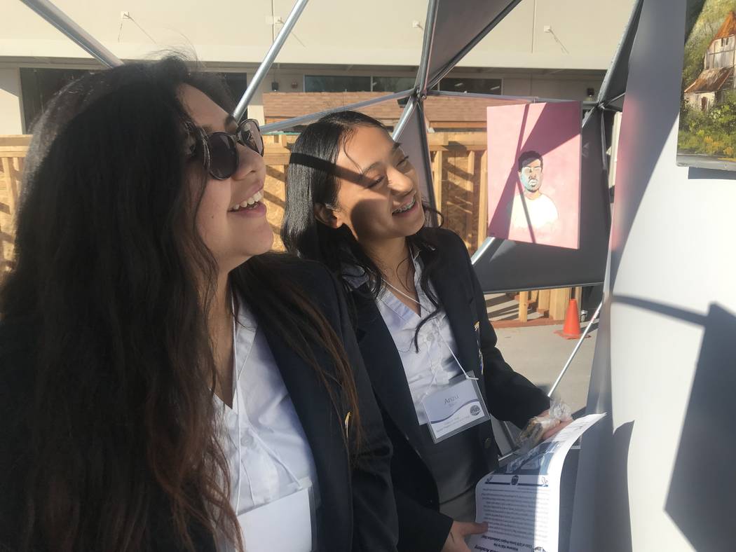 Odalys Jimenez, 17, (left)and Arizu Toriz, 16, stand in an art gallery at the school during the presenting of Capstone Projects at the East Career and Technical Academy on Friday, March 15. (Mia S ...