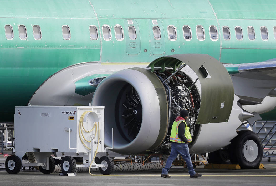 FILE- In this March 13, 2019, file photo a worker walks past an engine on a Boeing 737 MAX 8 airplane being built for American Airlines at Boeing Co.'s Renton assembly plant in Renton, Wash. U.S. ...