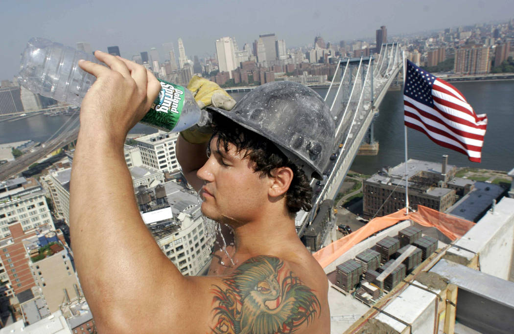 In this Tuesday Aug. 1, 2006 file photo, construction worker Eric Yanega pours water over his face as he takes a break from pouring concrete at a high-rise building project in the Dumbo section of ...