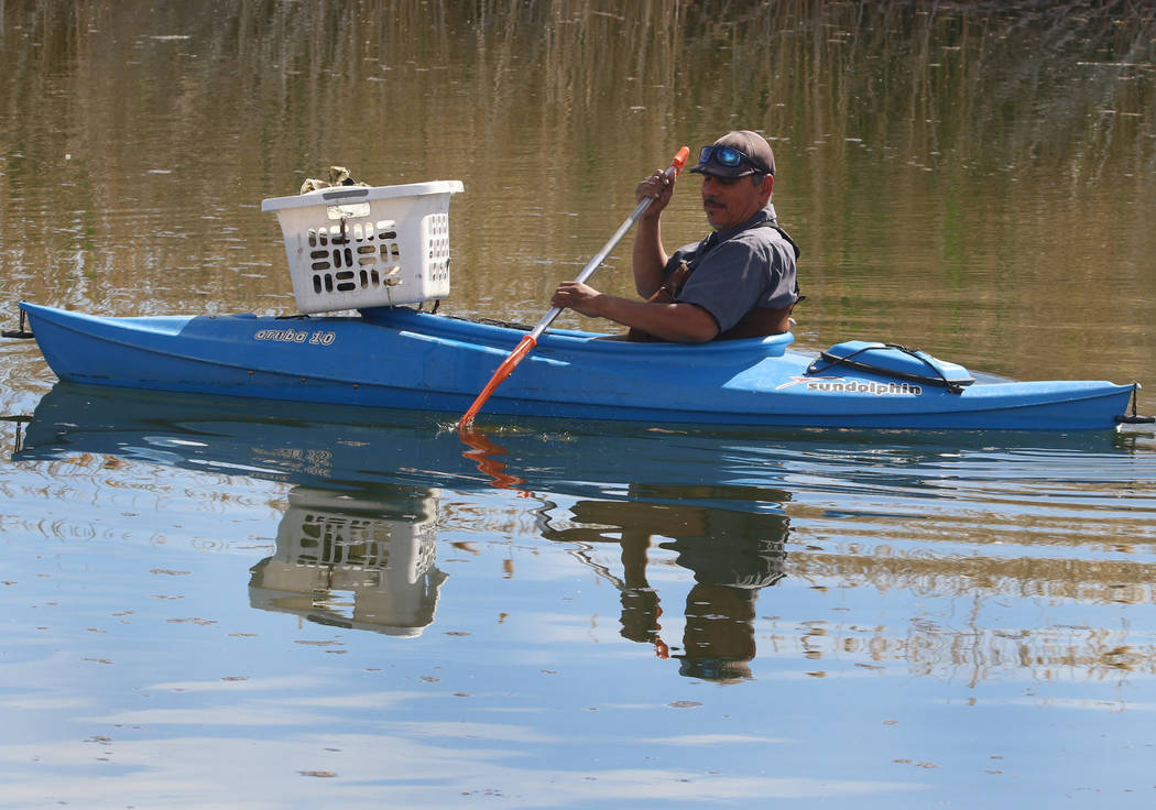 A man, who declined to give his name, kayaks as he collects trash from the lake at Cornerstone Park Tuesday, March. 19, 2019, in Henderson. (Bizuayehu Tesfaye/Las Vegas Review-Journal) @bizutesfaye