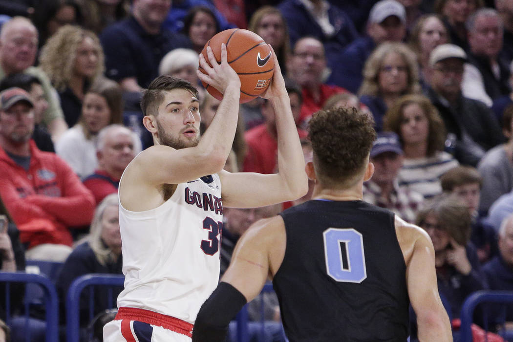 Gonzaga forward Killian Tillie, left, looks to pass in front of San Diego forward Isaiah Pineiro (0) during the second half of an NCAA college basketball game in Spokane, Wash., Saturday, Feb. 2, ...