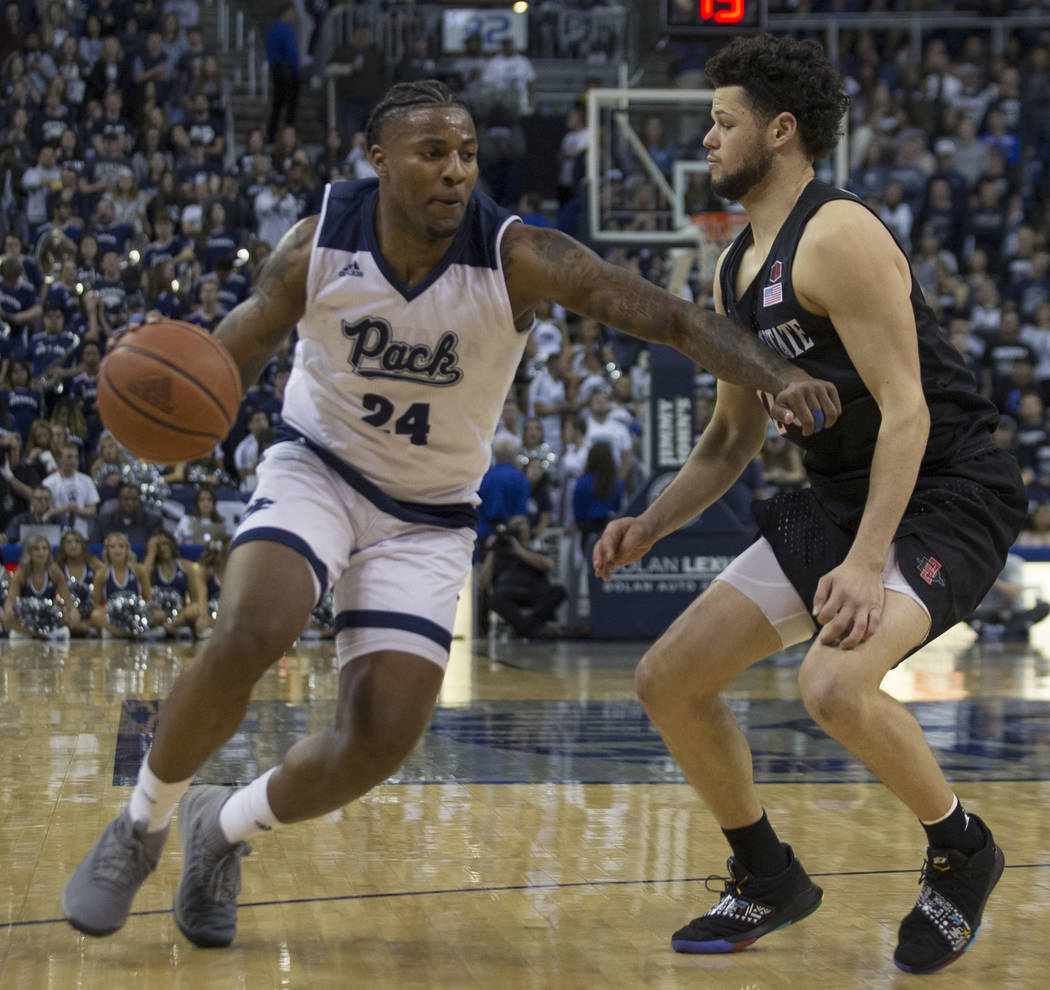 Nevada forward Jordan Caroline (24) drives past San Diego State guard Jordan Schakel (20) in the second half of an NCAA college basketball game in Reno, Nev., Saturday, March 9, 2019. (AP Photo/To ...