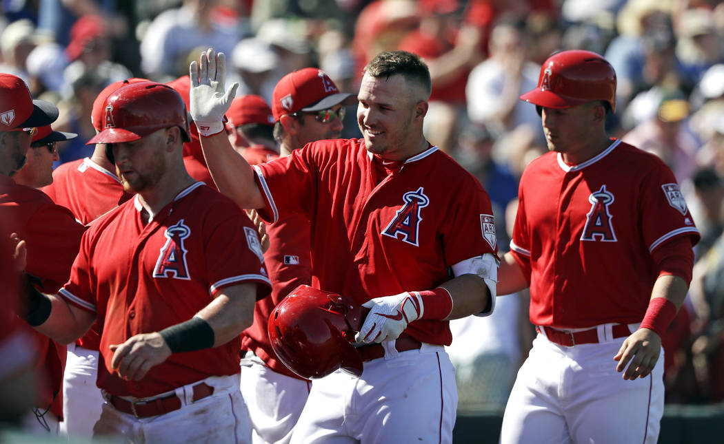 Los Angeles Angels' Mike Trout, center, is congratulated on his three-run home run against the Chicago Cubs in the third inning of a spring training baseball game Tuesday, March 5, 2019, in Tempe, ...