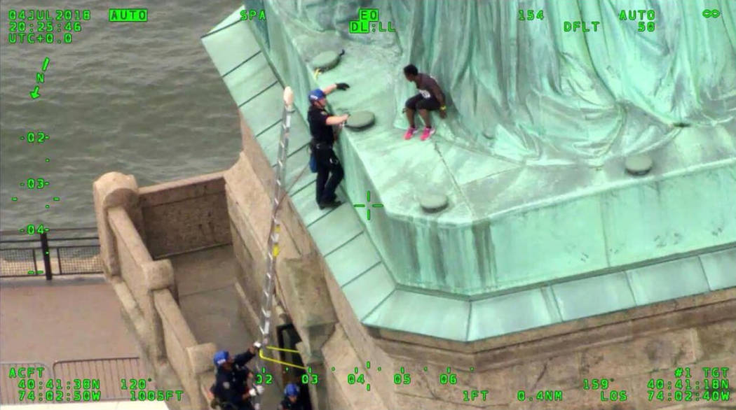Members of the New York City Police Department Emergency Service Unit work to safely remove Therese Okoumou, a protester who climbed onto the Statue of Liberty and was charged with misdemeanor tre ...