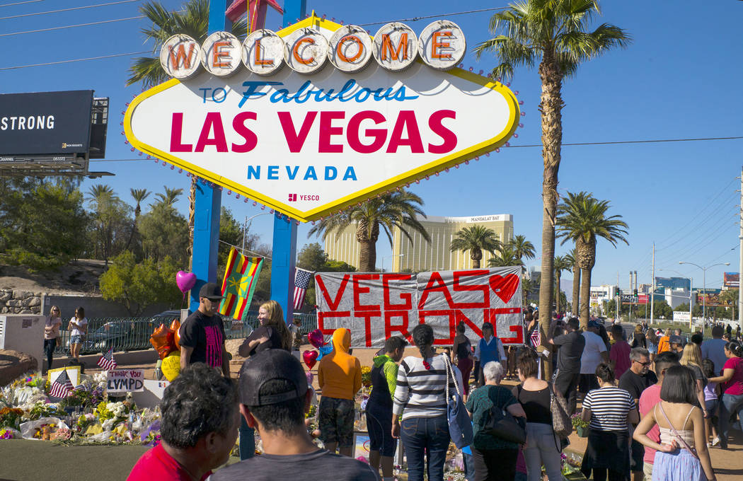 People visit a makeshift memorial for victims of the Oct. 1 mass shooting near the "Welcome to Fabulous Las Vegas" sign in Las Vegas on Saturday, Oct. 7, 2017. Chase Stevens Las Vegas Review-Journ ...