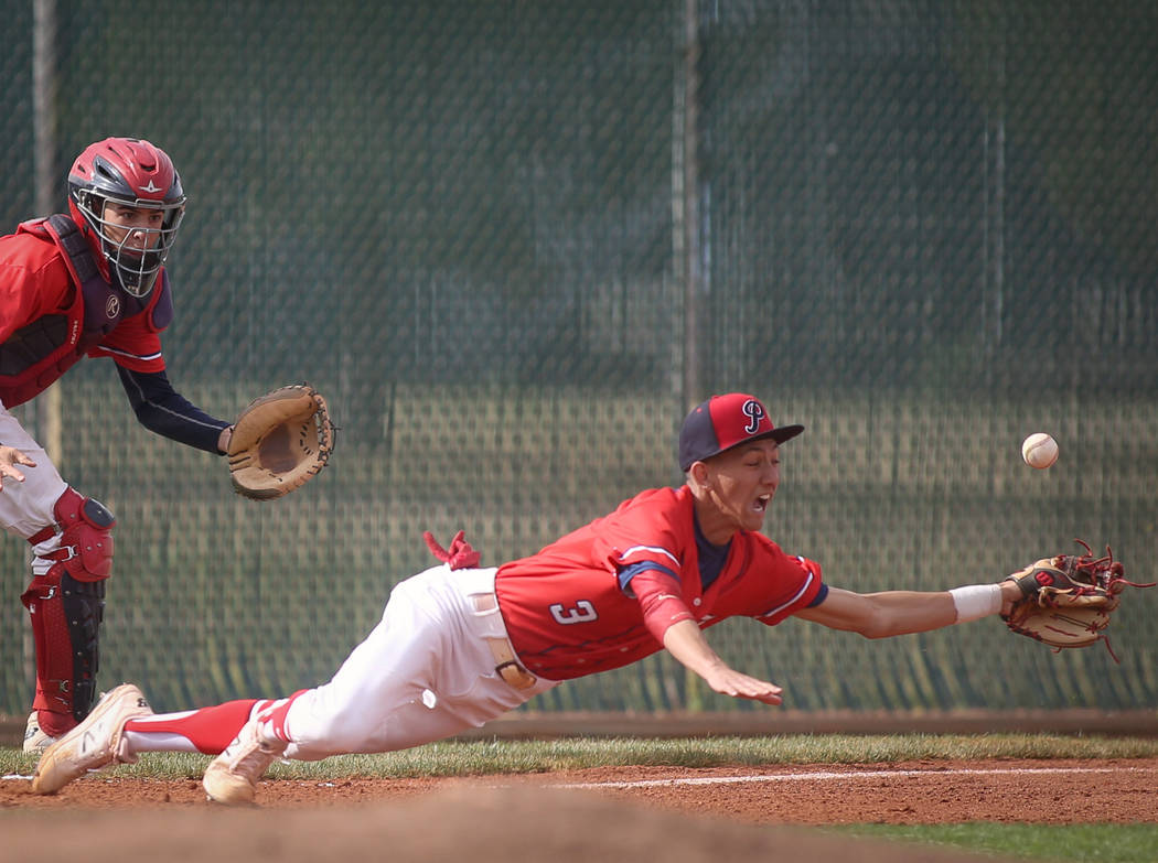 Liberty's Dylan San Nicolas (3) dives for a ground ball as James Katona (11) trails behind in the first inning of a baseball game at Liberty High School in Henderson, Tuesday, March 19, 2019. (Ca ...