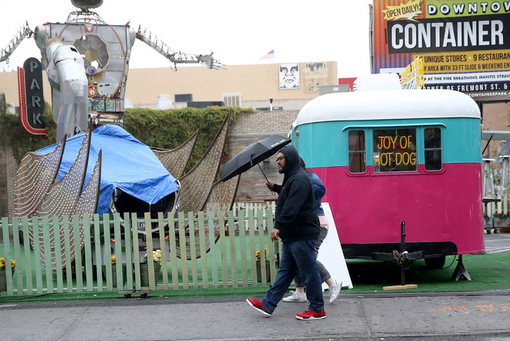 Walter Paul and his fiancee Jo Coleman walk in the rain on Las Vegas Boulevard at Fremont Street Wednesday, March 20, 2019. (K.M. Cannon/Las Vegas Review-Journal) @KMCannonPhoto