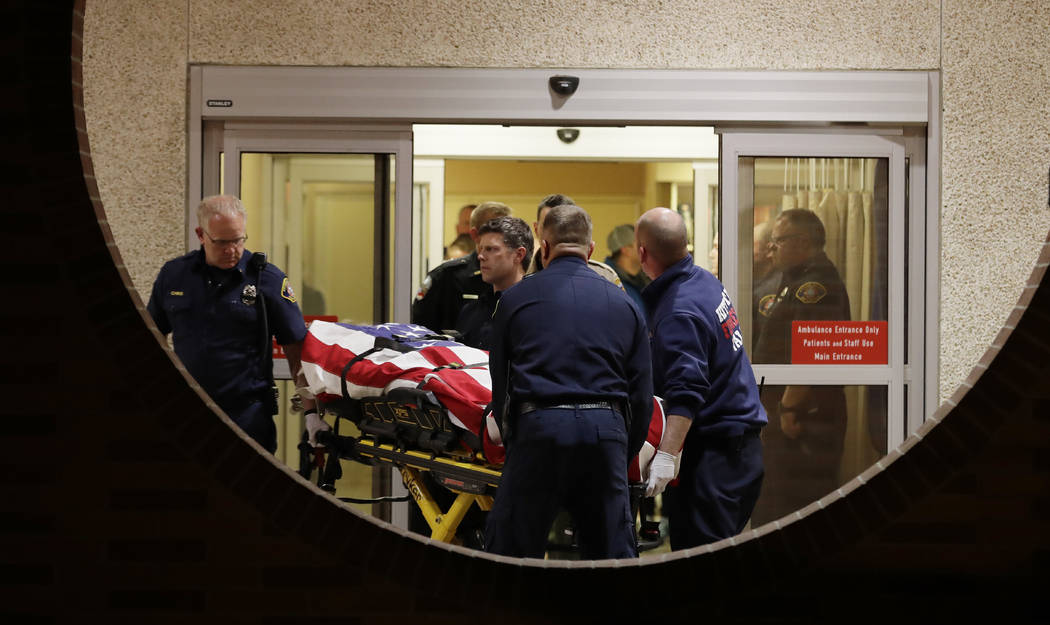 The body of a Kittitas County Sheriff's deputy is draped with a U.S. flag as it is carried out of Kittitas Valley Healthcare Hospital, in the early morning hours of Wednesday, March 20, 2019, in E ...