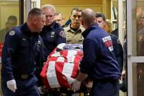 The body of a Kittitas County Sheriff's deputy is draped with a U.S. flag as it is carried out of Kittitas Valley Healthcare Hospital in the early morning hours of Wednesday, March 20, 2019, in El ...