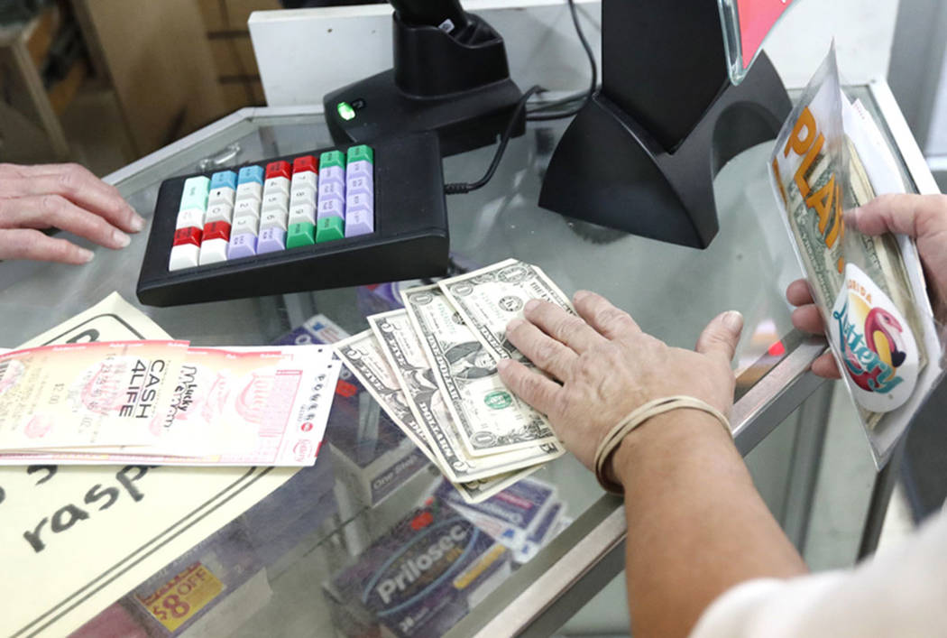 A customer purchases lottery tickets at La Preferida Superdiscount store in Hialeah, Fla., in 2018. (AP Photo/Wilfredo Lee)