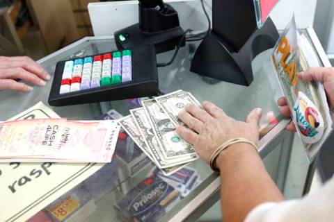 A customer purchases lottery tickets at La Preferida Superdiscount store in Hialeah, Fla., in 2018. (AP Photo/Wilfredo Lee)