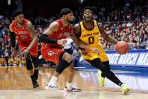 Arizona State's Luguentz Dort (0) drives against St. John's Marvin Clark II, center, during the first half of a First Four game of the NCAA men's college basketball tournament Wednesday, March 20, ...