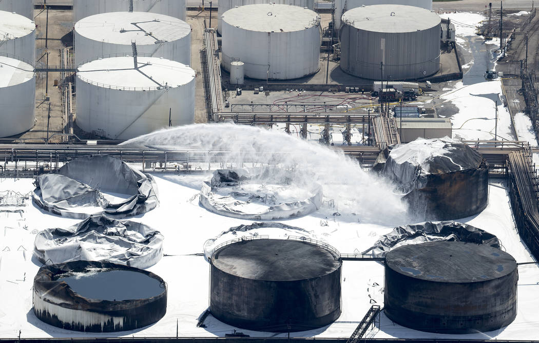 Emergency crews continue to douse what's left of the now-extinguished petrochemical tank fire at Intercontinental Terminals Company on Wednesday, March 20, 2019, in Deer Park. ITC officials said t ...