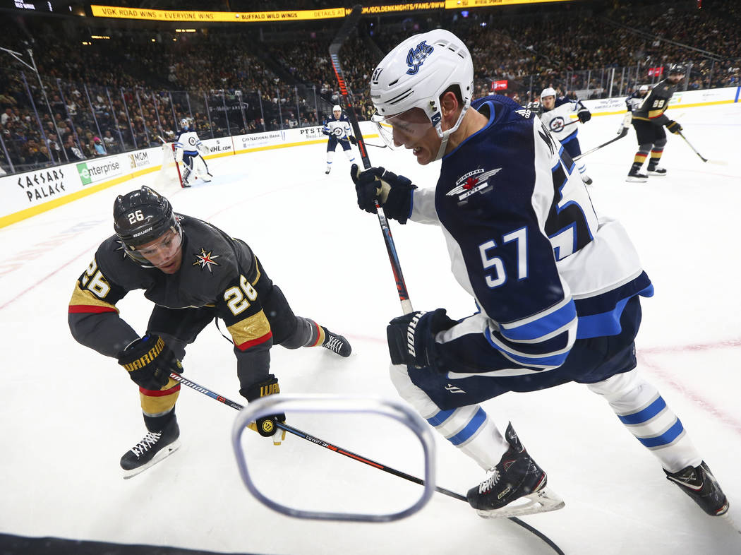 Golden Knights center Paul Stastny (26) and Winnipeg Jets defenseman Tyler Myers (57) battle for the puck during the second period of an NHL hockey game at T-Mobile Arena in Las Vegas on Friday, F ...